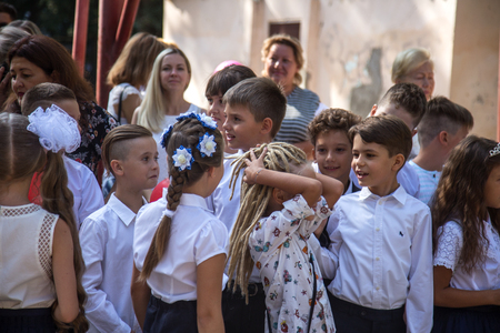ODESSA, UKRAINE September 1, 2018: September 1, day of the celebration of knowledge. Smiling happy first graders and their happy parents. Teacher in schoolyard holiday Beginning of the training yearのeditorial素材