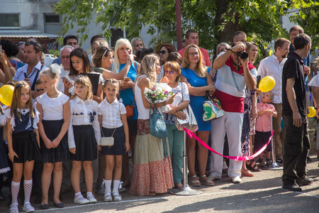 ODESSA, UKRAINE September 1, 2018: September 1, day of the celebration of knowledge. Smiling happy first graders and their happy parents. Teacher in schoolyard holiday Beginning of the training yearのeditorial素材