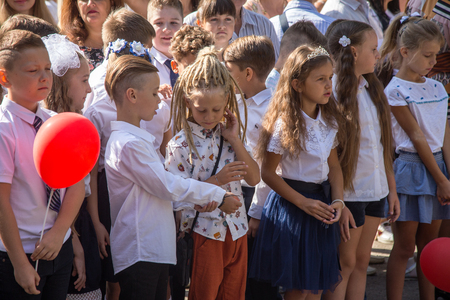 ODESSA, UKRAINE September 1, 2018: September 1, day of the celebration of knowledge. Smiling happy first graders and their happy parents. Teacher in schoolyard holiday Beginning of the training yearのeditorial素材
