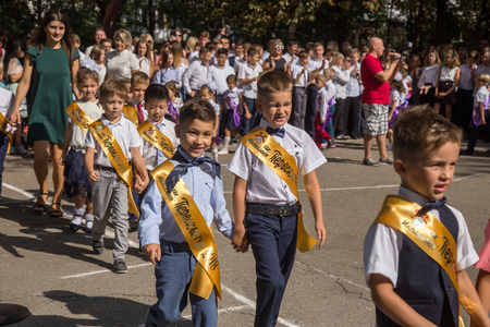 ODESSA, UKRAINE September 1, 2018: September 1, day of the celebration of knowledge. Smiling happy first graders and their happy parents. Teacher in schoolyard holiday Beginning of the training yearのeditorial素材