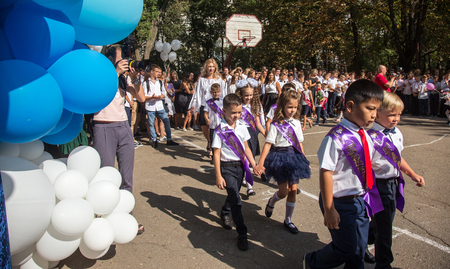 ODESSA, UKRAINE September 1, 2018: September 1, day of the celebration of knowledge. Smiling happy first graders and their happy parents. Teacher in schoolyard holiday Beginning of the training yearのeditorial素材