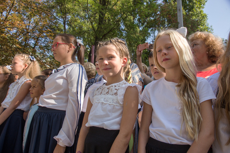 ODESSA, UKRAINE September 1, 2018: September 1, day of the celebration of knowledge. Smiling happy first graders and their happy parents. Teacher in schoolyard holiday Beginning of the training yearのeditorial素材