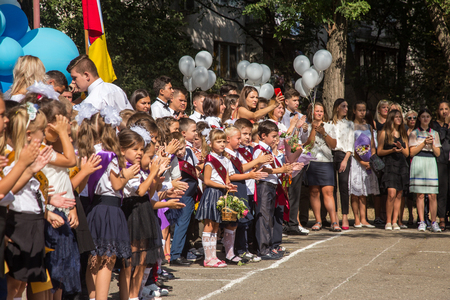 ODESSA, UKRAINE September 1, 2018: September 1, day of the celebration of knowledge. Smiling happy first graders and their happy parents. Teacher in schoolyard holiday Beginning of the training yearのeditorial素材