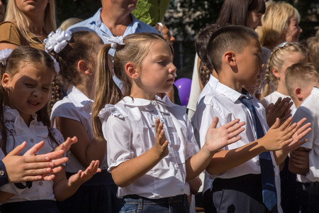 ODESSA, UKRAINE September 1, 2018: September 1, day of the celebration of knowledge. Smiling happy first graders and their happy parents. Teacher in schoolyard holiday Beginning of the training yearのeditorial素材