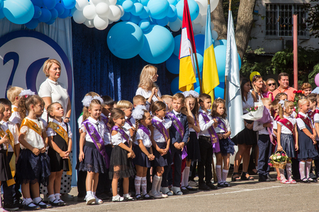 ODESSA, UKRAINE September 1, 2018: September 1, day of the celebration of knowledge. Smiling happy first graders and their happy parents. Teacher in schoolyard holiday Beginning of the training yearのeditorial素材