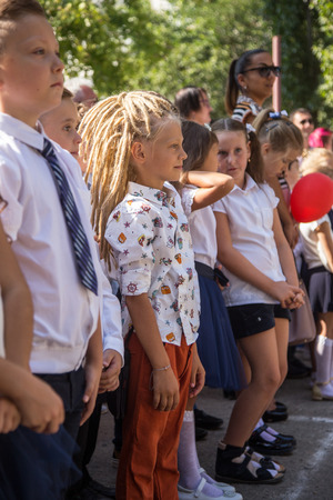 ODESSA, UKRAINE September 1, 2018: September 1, day of the celebration of knowledge. Smiling happy first graders and their happy parents. Teacher in schoolyard holiday Beginning of the training yearのeditorial素材