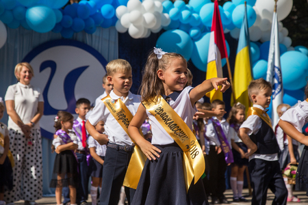 ODESSA, UKRAINE September 1, 2018: September 1, day of the celebration of knowledge. Smiling happy first graders and their happy parents. Teacher in schoolyard holiday Beginning of the training yearのeditorial素材
