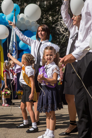 ODESSA, UKRAINE September 1, 2018: September 1, day of the celebration of knowledge. Smiling happy first graders and their happy parents. Teacher in schoolyard holiday Beginning of the training yearのeditorial素材