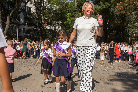 ODESSA, UKRAINE September 1, 2018: September 1, day of the celebration of knowledge. Smiling happy first graders and their happy parents. Teacher in schoolyard holiday Beginning of the training yearのeditorial素材