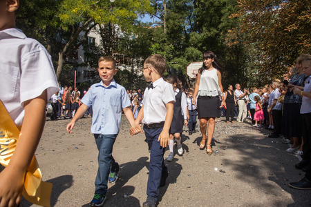 ODESSA, UKRAINE September 1, 2018: September 1, day of the celebration of knowledge. Smiling happy first graders and their happy parents. Teacher in schoolyard holiday Beginning of the training yearのeditorial素材