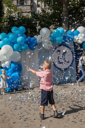 ODESSA, UKRAINE September 1, 2018: September 1, day of the celebration of knowledge. Smiling happy first graders and their happy parents. Teacher in schoolyard holiday Beginning of the training yearのeditorial素材