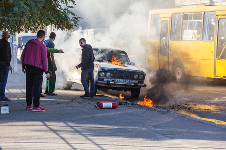 ODESSA, UKRAINE - Oct. 13 2018: Burning car in middle of highway. Sudden Fire from short circuit wiring an old car. Fire in engine compartment began to absorb entire old car is on fire. Road accidentのeditorial素材