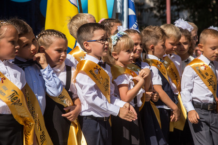 ODESSA, UKRAINE September 1, 2018: September 1, day of the celebration of knowledge. Smiling happy first graders and their happy parents. Teacher in schoolyard holiday Beginning of the training yearのeditorial素材
