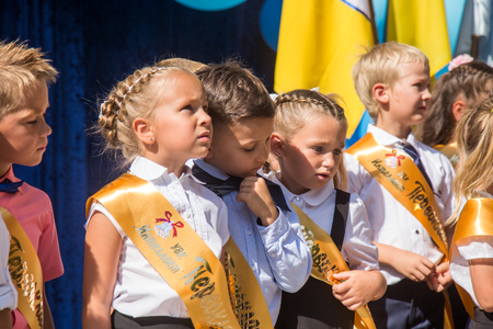 ODESSA, UKRAINE September 1, 2018: September 1, day of the celebration of knowledge. Smiling happy first graders and their happy parents. Teacher in schoolyard holiday Beginning of the training yearのeditorial素材