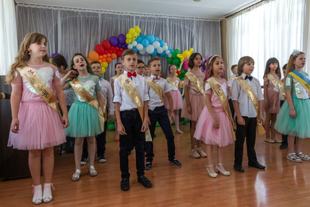 Odessa, Ukraine - May 31,2018: Children's musical group sing and dance on stage during graduation concert of elementary school. Children play. Emotional children's show on stage. Children's creativityのeditorial素材