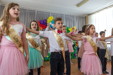 Odessa, Ukraine - May 31,2018: Children's musical group sing and dance on stage during graduation concert of elementary school. Children play. Emotional children's show on stage. Children's creativityのeditorial素材