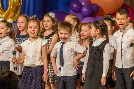 Odessa, Ukraine - May 31,2018: Children's musical group sing and dance on stage during graduation concert of elementary school. Children play. Emotional children's show on stage. Children's creativityのeditorial素材