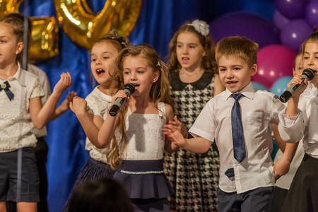 Odessa, Ukraine - May 31,2018: Children's musical group sing and dance on stage during graduation concert of elementary school. Children play. Emotional children's show on stage. Children's creativityのeditorial素材