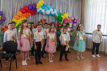 Odessa, Ukraine - May 31,2018: Children's musical group sing and dance on stage during graduation concert of elementary school. Children play. Emotional children's show on stage. Children's creativityのeditorial素材