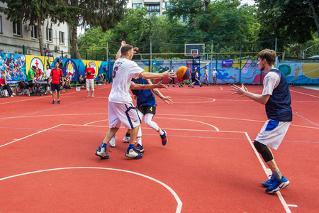 ODESSA, UKRAINE - JULY 28, 2018: Adolescents play basketball during 3x3 streetball championship. Young people play street basketball on an open city sports ground. Streetball - street culturesのeditorial素材