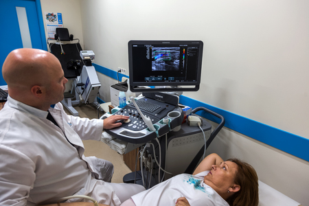 ODESSA, UKRAINE - July 29, 2018: Woman undergoes medical examination of veins on ultrasound sensor in modern technology clinic. Condition of veins and examination of doppler on monitorのeditorial素材