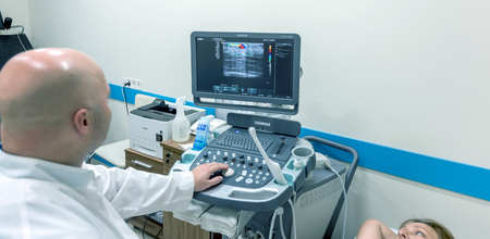 ODESSA, UKRAINE - July 29, 2018: Woman undergoes medical examination of veins on ultrasound sensor in modern technology clinic. Condition of veins and examination of doppler on monitorのeditorial素材