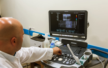 ODESSA, UKRAINE - July 29, 2018: Woman undergoes medical examination of veins on ultrasound sensor in modern technology clinic. Condition of veins and examination of doppler on monitorのeditorial素材