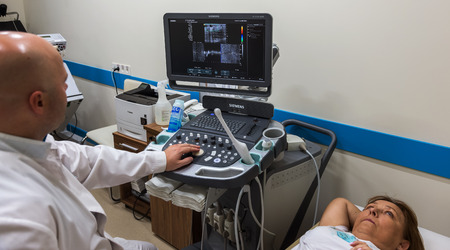 ODESSA, UKRAINE - July 29, 2018: Woman undergoes medical examination of veins on ultrasound sensor in modern technology clinic. Condition of veins and examination of doppler on monitorのeditorial素材