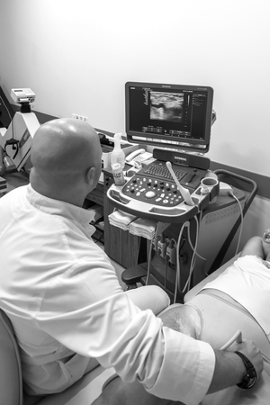 ODESSA, UKRAINE - July 29, 2018: Woman undergoes medical examination of veins on ultrasound sensor in modern technology clinic. Condition of veins and examination of doppler on monitorのeditorial素材