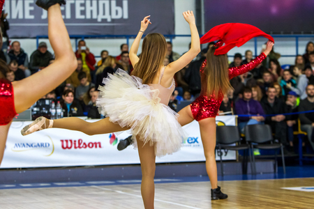 ODESSA, UKRAINE - March 15, 2018: Speech by the beautiful young girls of the fan team during the opening of the basketball championship. Team performance of the team on the parquet gymのeditorial素材