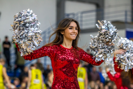 ODESSA, UKRAINE - March 15, 2018: Speech by the beautiful young girls of the fan team during the opening of the basketball championship. Team performance of the team on the parquet gymのeditorial素材