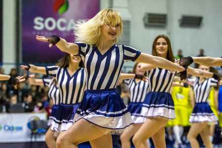 ODESSA, UKRAINE - March 15, 2018: Speech by the beautiful young girls of the fan team during the opening of the basketball championship. Team performance of the team on the parquet gymのeditorial素材
