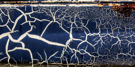 Background of old cracked paint. Large cracks on the surface. Close the layers; many paint and paper layers give an abstract texture; macro peeling of the painted surface creates the backgroundの写真素材
