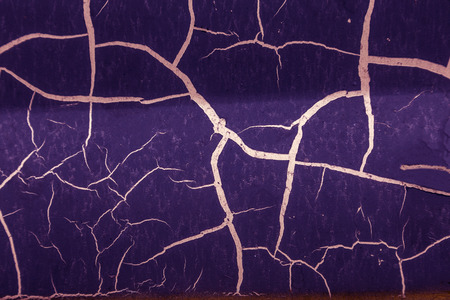 Background of old cracked paint. Large cracks on the surface. Close the layers; many paint and paper layers give an abstract texture; macro peeling of the painted surface creates the backgroundの写真素材