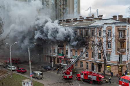 Odessa, Ukraine - Dec. 29, 2016: A fire in an apartment building. Strong bright light and clubs, smoke clouds window of their burning house. Firefighters extinguish fire in house. Work on fire stairsのeditorial素材