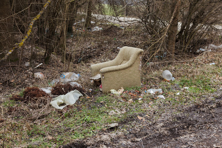 Garbage in forest. People illegally throw garbage into forest. Concept of man and nature. Illegal garbage dump in nature. Dirty environment garbage polluting near footpath in forest. Rubbish, trashの写真素材