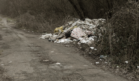 Garbage in forest. People illegally throw garbage into forest. Concept of man and nature. Illegal garbage dump in nature. Dirty environment garbage polluting near footpath in forest. Rubbish, trashの写真素材