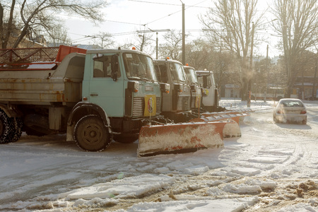 ODESSA, UKRAINE - JANUARY 27, 2019: Special snow removal vehicles on road during a snowfall. Front view of snow plow machine with basket for sand and salt on town square in winter. Ð¡ar clears snowのeditorial素材