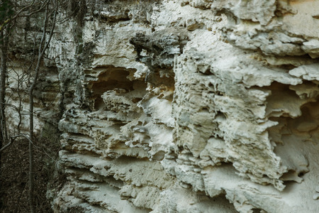 Picturesque background of collapsing surface of limestone rock. Abstract beautiful forms of...