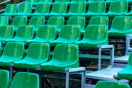 Empty old plastic chairs in the stands of the summer theater. Many empty seats for spectators in the stands of the amphitheater. Empty plastic chairs, seating for the audience. Plastic potの写真素材