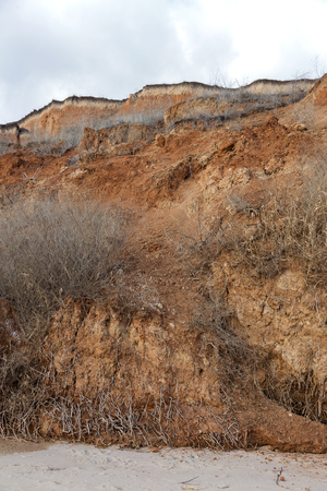 Landslide zone on Black Sea coast. Rock of sea rock shell. Zone of natural disasters during rainy season. Large masses of earth slip along slope of hill, destroy houses. Landslide - threat to lifeの写真素材