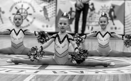 Odessa, Ukraine - Febr 16, 2019: Bright dynamic characteristics of a support group of women's sports team. Performance Support Group. Bright beautiful young girl in sports dance form on the playgroundのeditorial素材