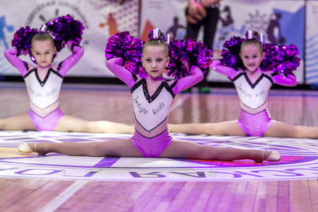 Odessa, Ukraine - Febr 16, 2019: Bright dynamic characteristics of a support group of women's sports team. Performance Support Group. Bright beautiful young girl in sports dance form on the playgroundのeditorial素材