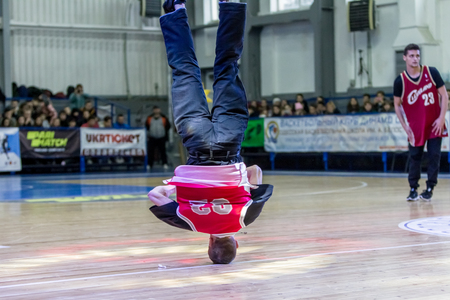 Odessa, Ukraine - February 16, 2019: street dancers, children and teenagers dance break dance on the basketball court during the commercial break. Hip-hop dancers perform at the sports arenaのeditorial素材