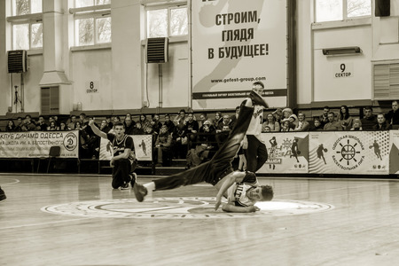 Odessa, Ukraine - February 16, 2019: street dancers, children and teenagers dance break dance on the basketball court during the commercial break. Hip-hop dancers perform at the sports arenaのeditorial素材
