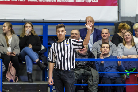 Odessa, Ukraine - February 16, 2019: A sports basketball referee oversees the battle of basketball players on the court during a game. Special gestures and signs of the basketball referee during gameのeditorial素材