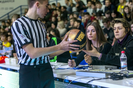 Odessa, Ukraine - February 16, 2019: A sports basketball referee oversees the battle of basketball players on the court during a game. Special gestures and signs of the basketball referee during gameのeditorial素材