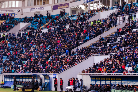 ODESSA, UKRAINE -2 March 2019: Crowds of fans in the stands of the football stadium during the match Shakhtar (Donetsk). Spectators at the stadium. Fayer, lights in the stadiums football stadiumのeditorial素材