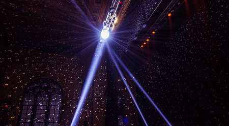 Stage lights. Several projectors in the dark. Multi-colored light beams from the stage spotlights on...