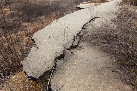 Landslide caused by rains of hurricane destroyed expensive cottages and houses. Destroyed house, cottage, large cracks, chips, slabs. Broken asphalt shifted landslide after earthquake. View from droneの写真素材